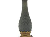 an image of a green vase with a gold base and a bird on top