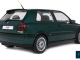 a green car that is parked on a white surface