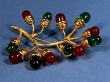 an image of a brooch with red, green, and gold beads