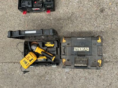 Deux outils sont posés par terre à côté d'une boîte à outils.