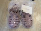 two pairs of pink sandals in a plastic bag on the floor