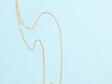 a gold necklace with a black star on it