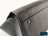 the back of a black leather purse with a metal clasp