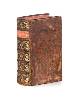 an old book sitting on top of a table next to a white background