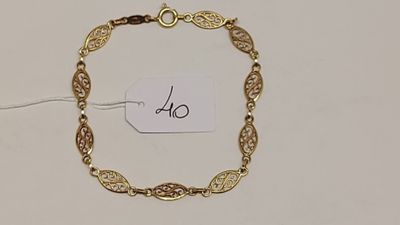 un bracelet en or muni d'une plaque, posé sur une table