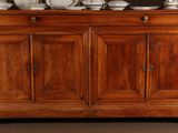 a wooden cabinet with plates and bowls on top of it