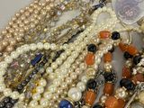 a lot of pearls and other jewelry on a table