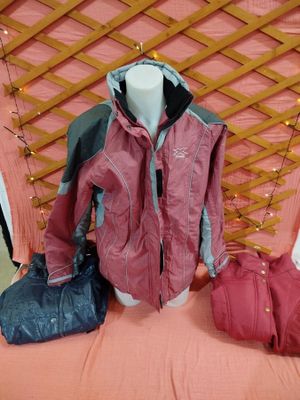 trois sacs et une veste posés sur un lit dans une chambre