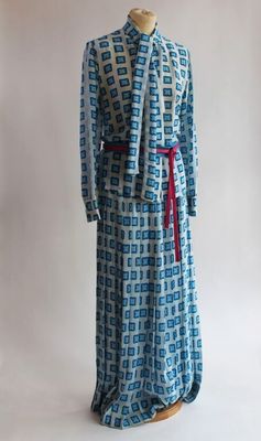 une robe bleue et blanche avec une ceinture rouge sur un mannequin
