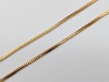 a pair of gold chains on a white background