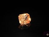 a close up of a diamond on a black surface with a black background