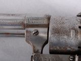 a close up of a gun on a white surface