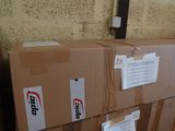 une pile de cartons posée par terre près d'un mur de briques