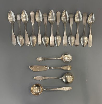 six cuillères en argent et deux cuillères en argent posées sur une surface grise