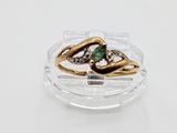 a gold ring with a green stone on top of a clear plate