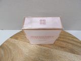 a pink box on a wooden table with a white wall in the background