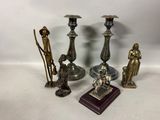 several different types of candlesticks and figurines on a table