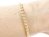 the woman is wearing a gold bracelet with diamonds on it