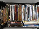 de nombreux DVD rangés dans un boîtier en plastique noir sur une étagère