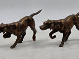 two bronze figurines of a dog and a cat on a white surface