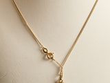 a close up of a mannequin with a gold necklace on it