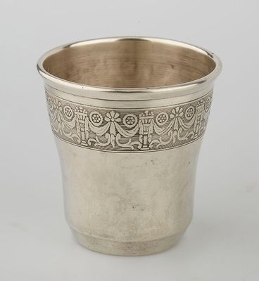 a silver cup with a floral design on the rim