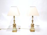 pair of brass table lamps with white shades on a white background