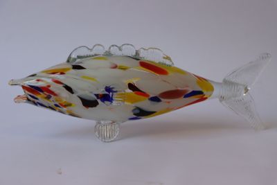 un poisson en verre posé sur une surface blanche