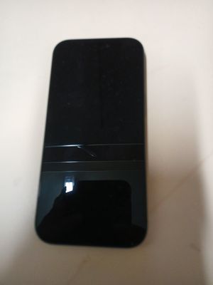 un téléphone portable noir posé sur une table blanche