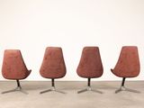 three red chairs sitting on top of each other in front of a white wall