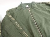 a close up of a green jacket with gold writing on it