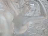 a glass vase with a sculpture of a woman on it