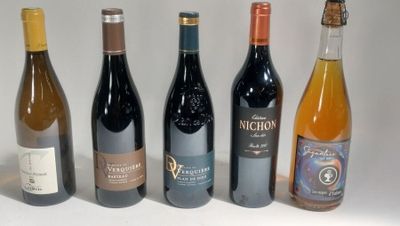 several bottles of wine are lined up on a white surface
