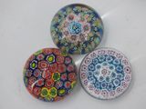 three glass magnets sitting on top of a white surface