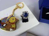 a blue box with a ring and a gold fish keychain