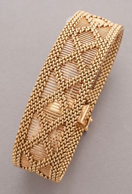 a gold bracelet with a woven design on it
