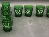 many green glasses with green leaves on them on a table