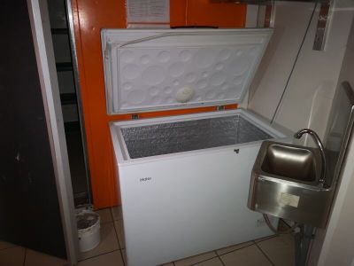 un réfrigérateur ouvert dans une petite cuisine équipée d'un évier