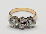 a close up of a three stone diamond ring on a white surface