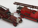 deux camions de pompiers miniatures posés l'un à côté de l'autre sur une surface blanche