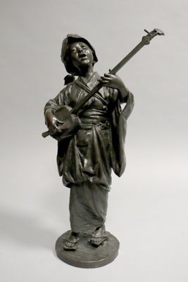 une statue représentant un homme avec une guitare, posée sur un socle