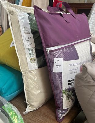 many pillows and bags on a table in a store