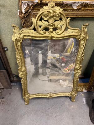 Miroir en bois doré à décor de volutes et fleurs