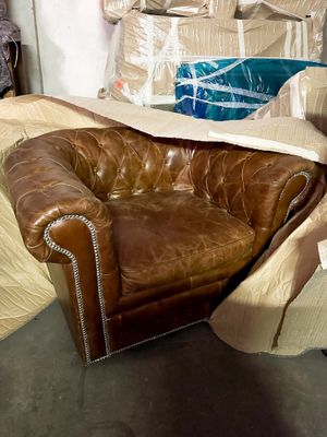 a brown leather chair that is sitting in a pile of boxes