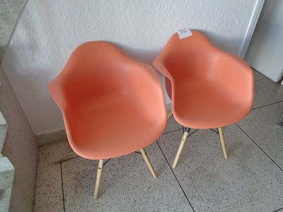 deux chaises orange placées l'une à côté de l'autre sur un sol carrelé