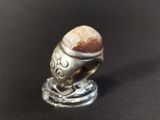 an image of a ring with a stone in it on a black surface