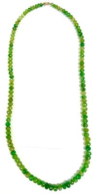 gros plan d'un collier de perles vertes sur fond blanc