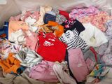 un tas de vêtements dans un sac en plastique posé par terre