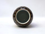a small vase that is sitting on a white surface