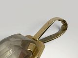 an image of a clear glass bottle with a gold handle